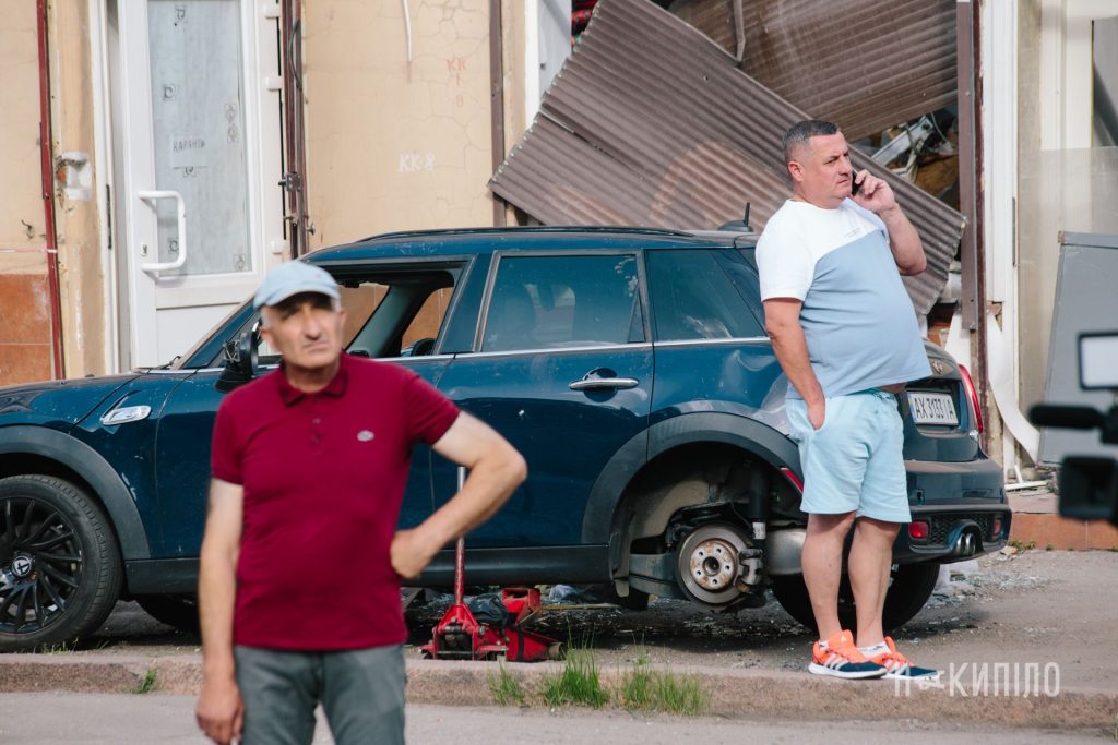 Мешканці будинків біля зруйнованих помешкань. Два чоловіки
