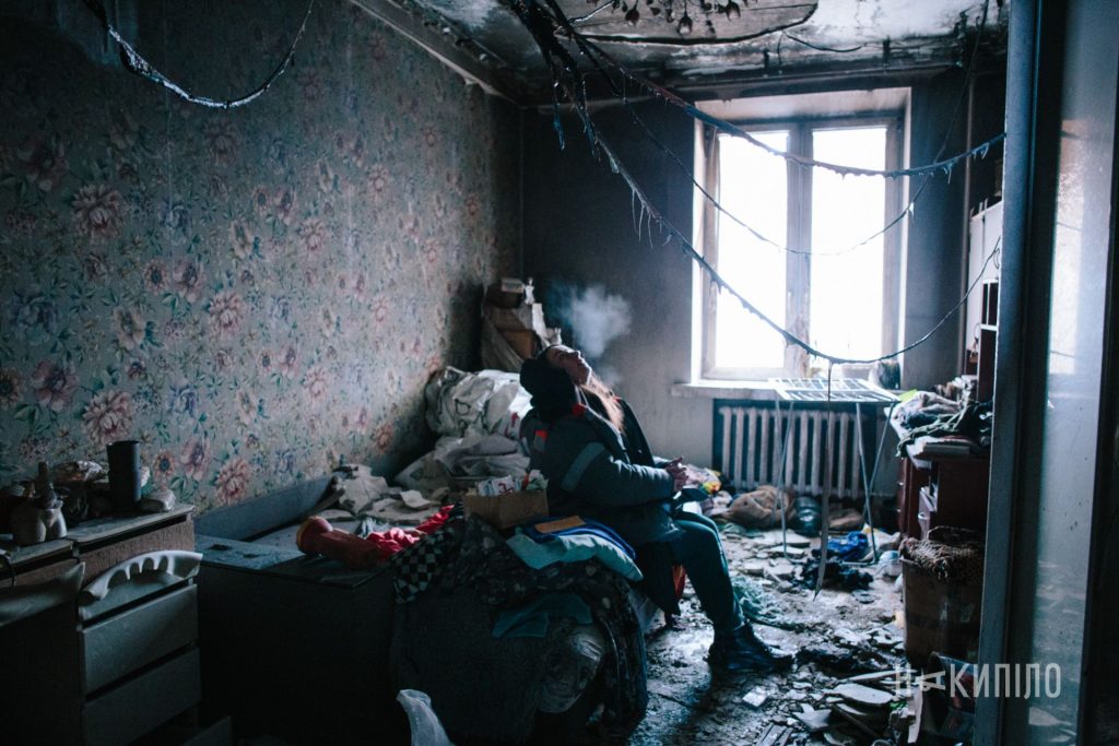 20 дронів і ракета: наслідки ударів по Харкову 3 дівчина сидить в кімнаті після обстрілу