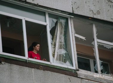 жінка дивіться у вікно, вибиті вікна