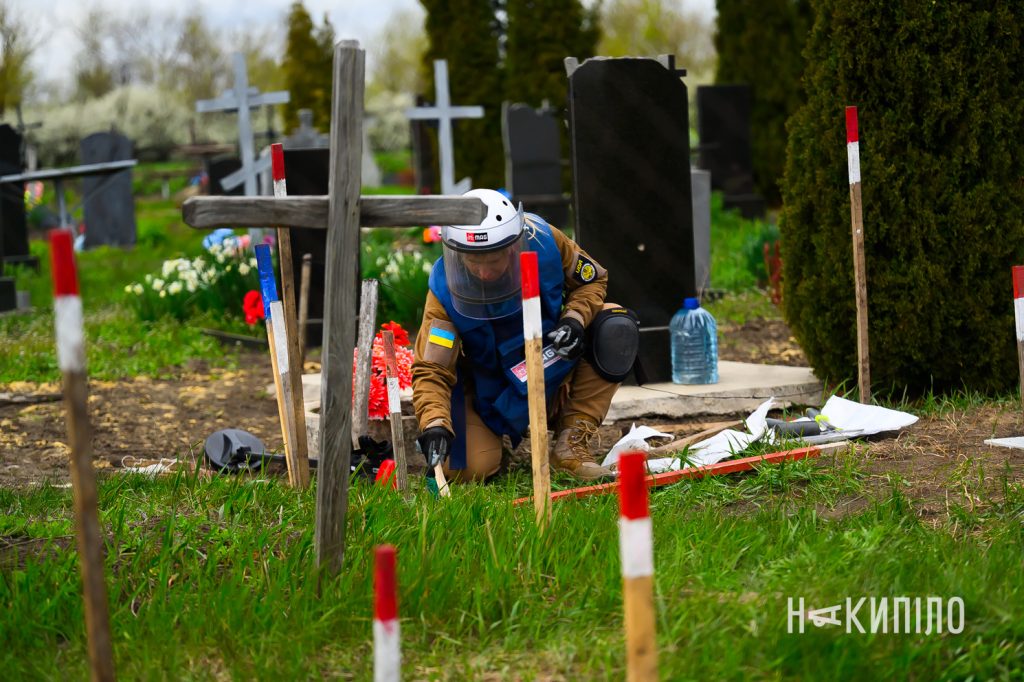 Повернути пам'ять: як демінери розміновують кладовища на Харківщині Саперка на кладовищі перевіряє територію на міни.