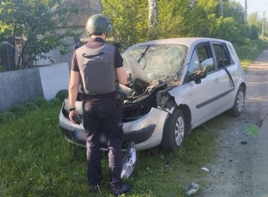 поліцейський стоїть біля пошкодженої машини