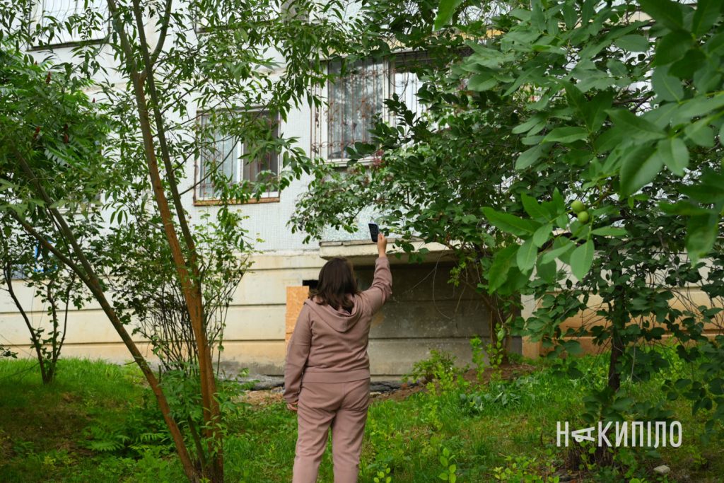 Наслідки обстрілу передмістя Харкова. Фоторепортаж Жителька Харкова фотографує пошкодження після влучання в передмісті