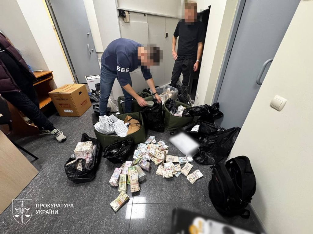 Працівники ДБР розбирають сумки з готівкою під час обшуків